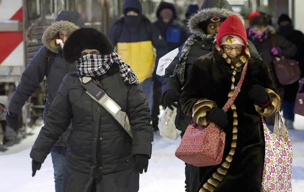 Commuters arrive at the La Salle Street commuter rail station as they experience temperatures well below zero and wind chills expected to reach 40 to 50 below.