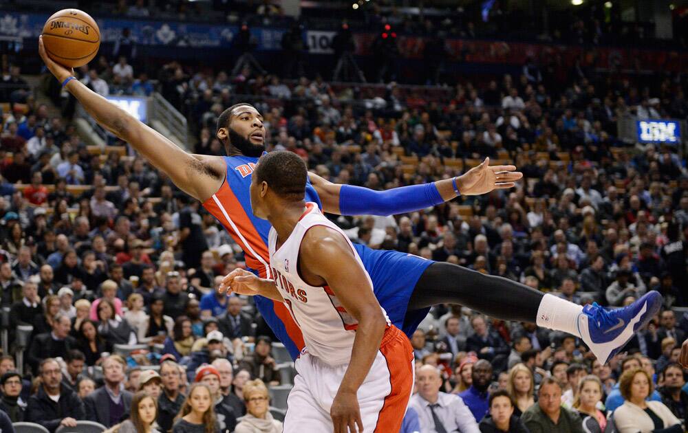 Detroit Pistons center Andre Drummond, top, lunges backward out of bounds to keep a ball in play as Toronto Raptors guard Kyle Lowry looks on during first-half NBA basketball game action in Toronto.