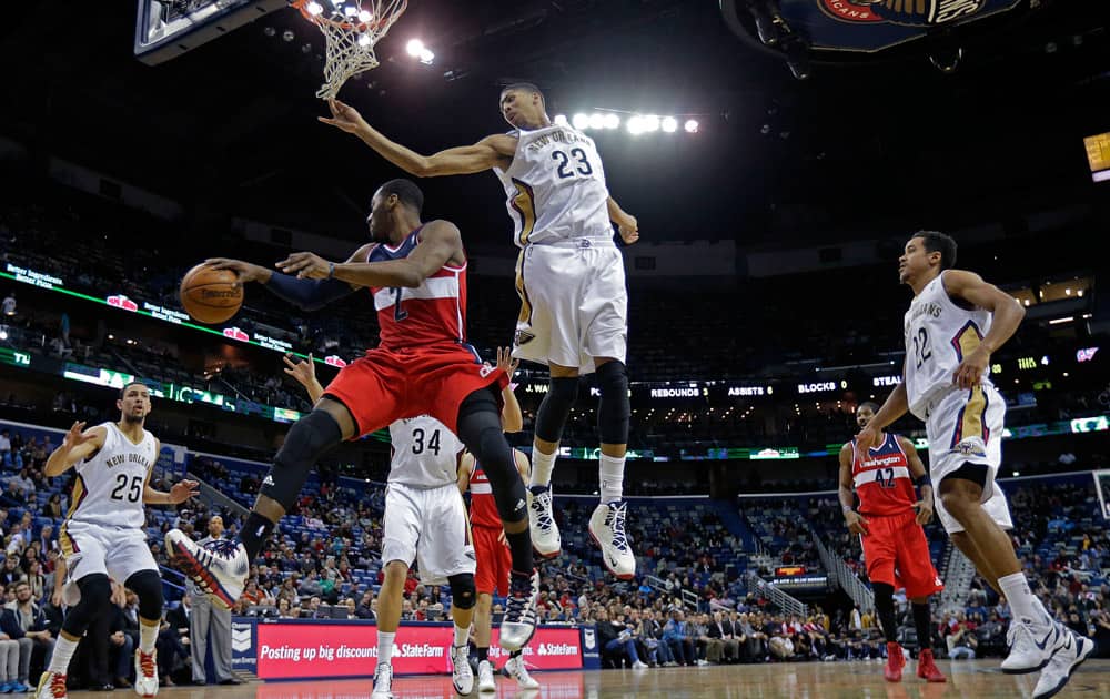Washington Wizards point guard John Wall (2) passes around New Orleans Pelicans power forward Anthony Davis (23), shooting guard Austin Rivers (25), center Greg Stiemsma (34) and point guard Brian Roberts (22) in the second half of an NBA basketball game in New Orleans.