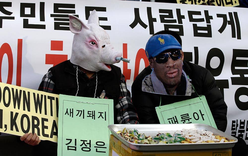 A protester wearing a mask of a pig depicting North Korean leader Kim Jong Un, left, and another wearing a mask of former NBA player Dennis Rodman, who is currently in Pyongyang with fellow former NBA players for a basketball game against a team of North Koreans, perform during an anti-North Korea rally on what is believed to be the birthday of Kim, in Seoul, South Korea.