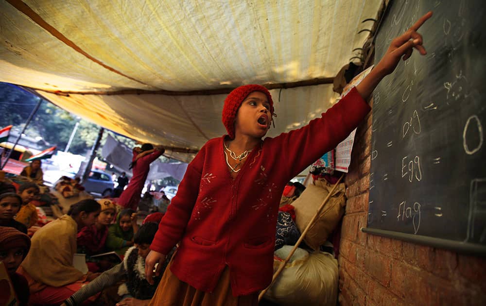 A Pakistani boy studies under a makeshift tent where he along with others is staging a protest to demand permanent residency in New Delhi, India.