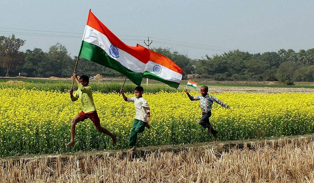 Young boys run with tri-colour flag in the mustard field ahead of Republic Day celebrations at a village near Balurghat in South Dinajpur district of West Bengal.