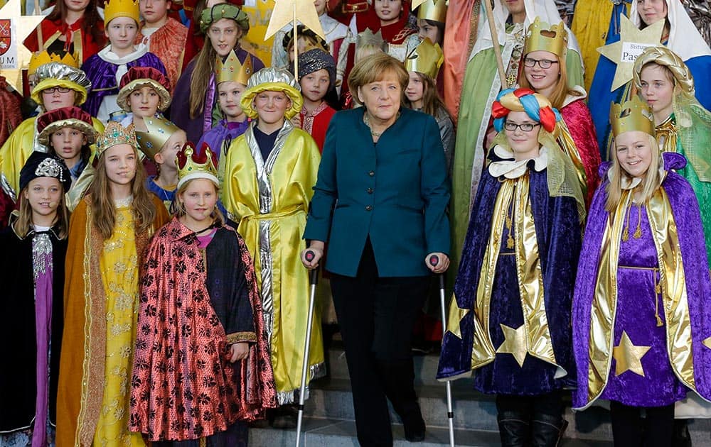 German Chancellor Angela Merkel stands on crutches as she attends the annual reception for Carolers at the chancellery in Berlin.