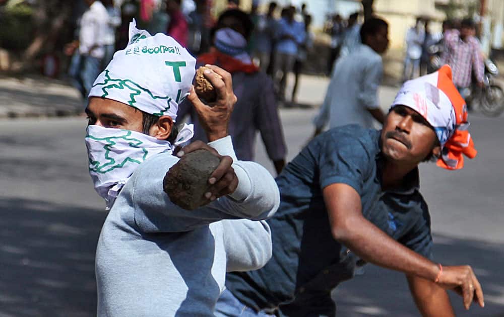Students supporting the creation of a separate state of Telangana throw stones at policemen during a protest in Hyderabad, India.
