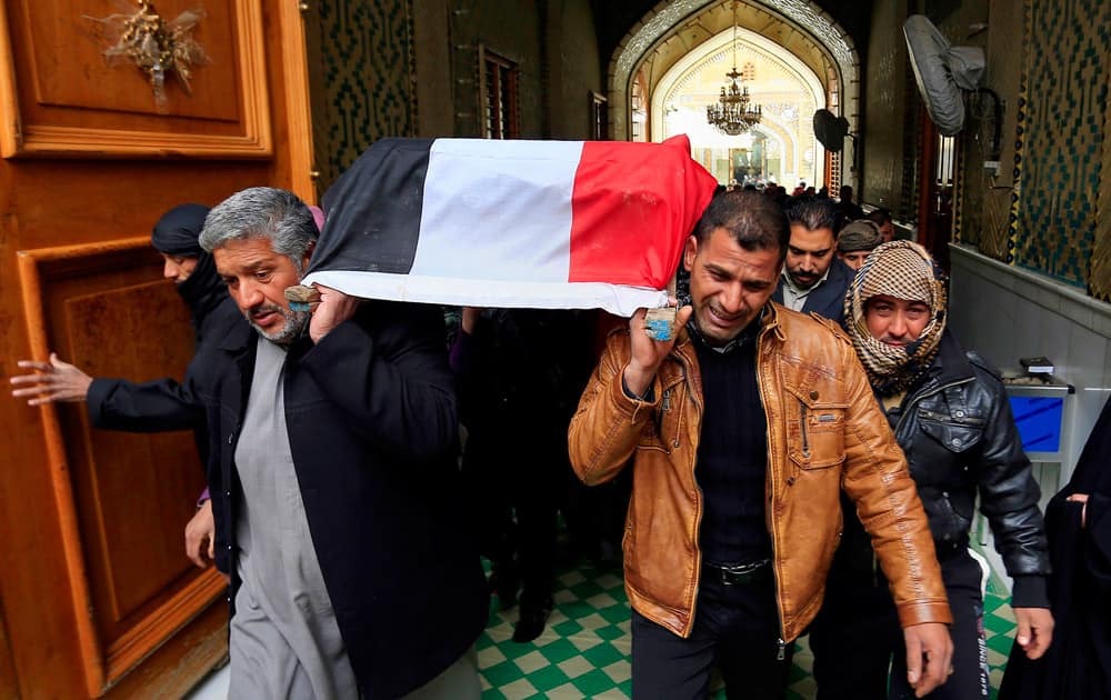 Mourners carry the flag-draped coffin of Iraqi soldier Layth Ahmed, who was killed during clashes in Ramadi, during his funeral procession in the Shiite holy city of Najaf, 100 miles (160 kilometers) south of Baghdad, Iraq.