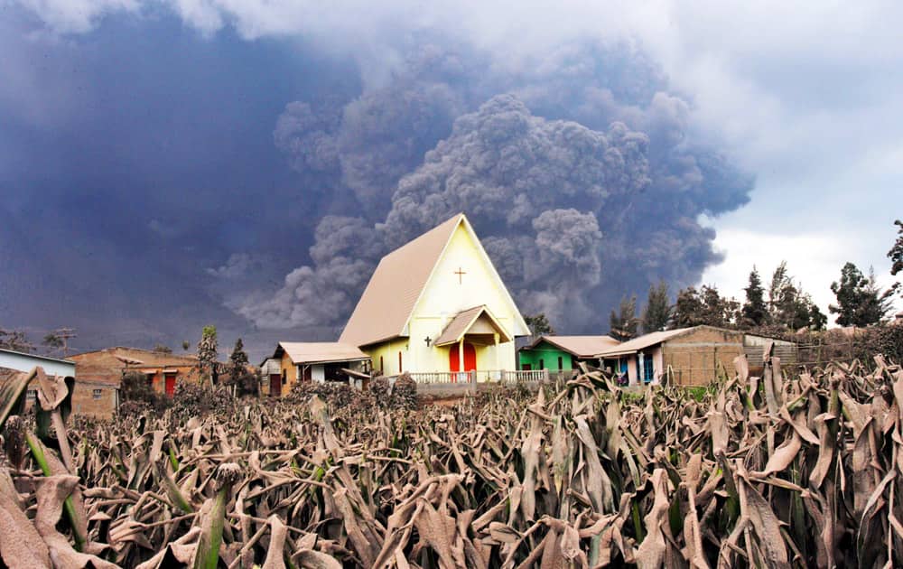 Mount Sinabung releases pyroclastic flow as a church is seen in the foreground in Sibintun, North Sumatra, Indonesia.