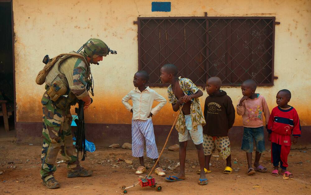 A French soldier talks to curious children as he mans a roadblock in the Miskine neighborhood of Bangui, Central African Republic.