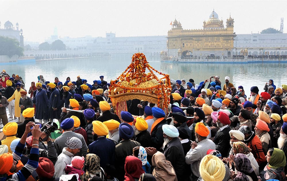 Sikh Devotees Carry Palanquin in Nagar Kiratan in the Parikarma of Golden Temple, to mark the Birth Anniversary of 10th Sikh Master Guru Gobind Singh ji.