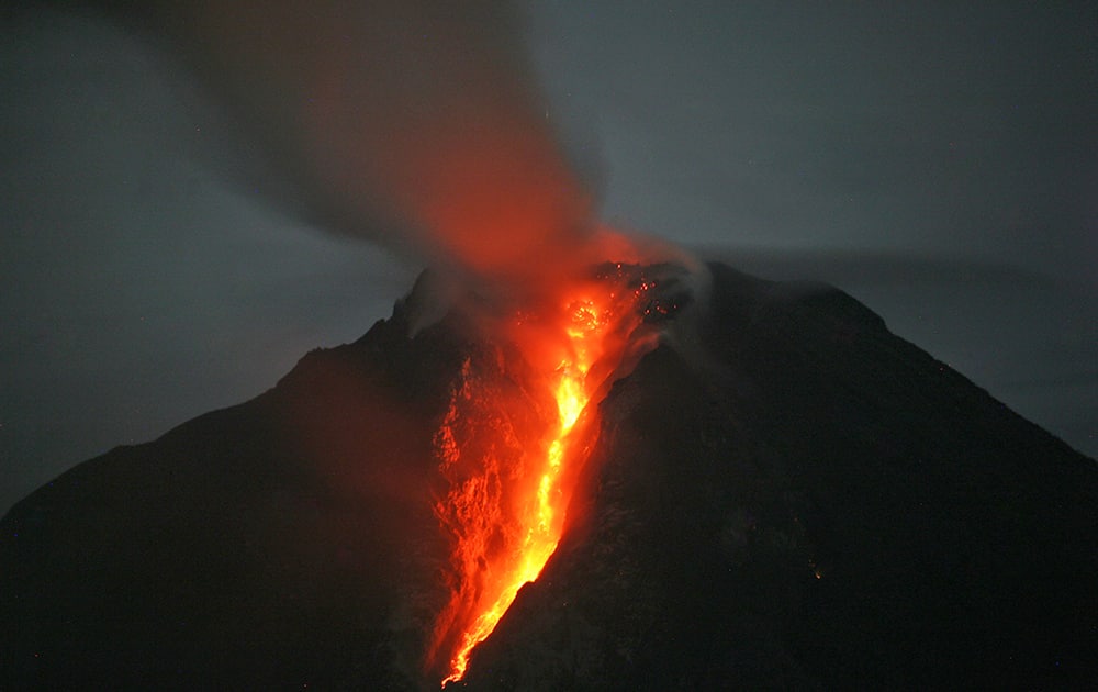 Mount Sinabung spews hot lava as seen from Jeraya, North Sumatra, Indonesia. The 2,600-meter (8,530-foot) volcano has sporadically erupted since September.