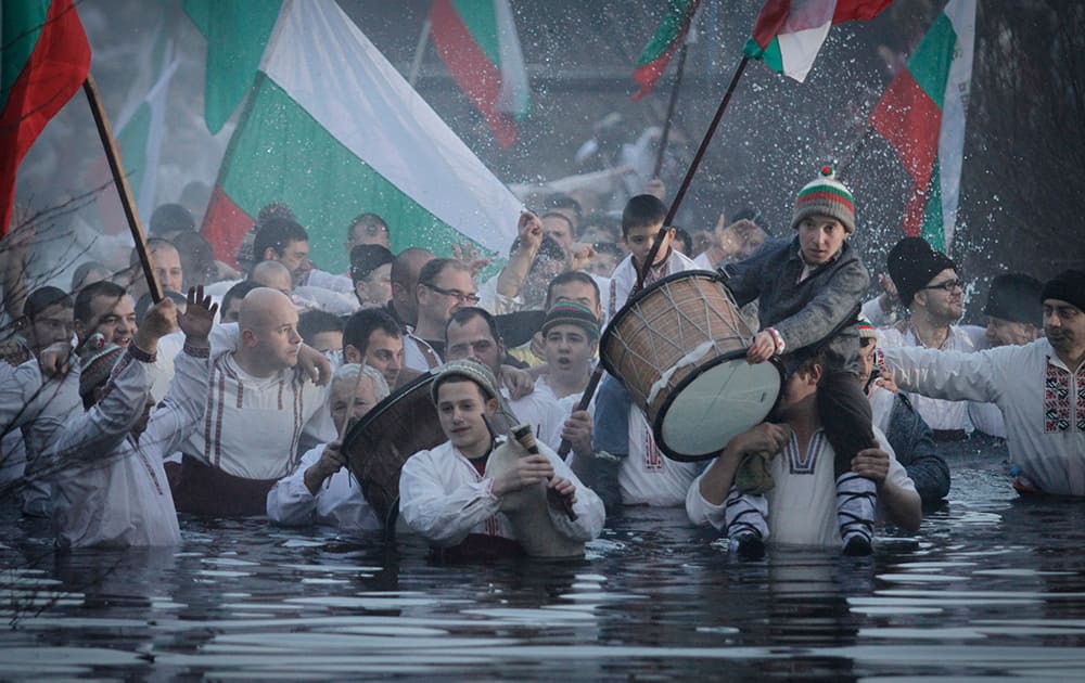 Believers sing and dance in the river Tundzha as they celebrate Epiphany day in the town of Kalofer, Bulgaria.