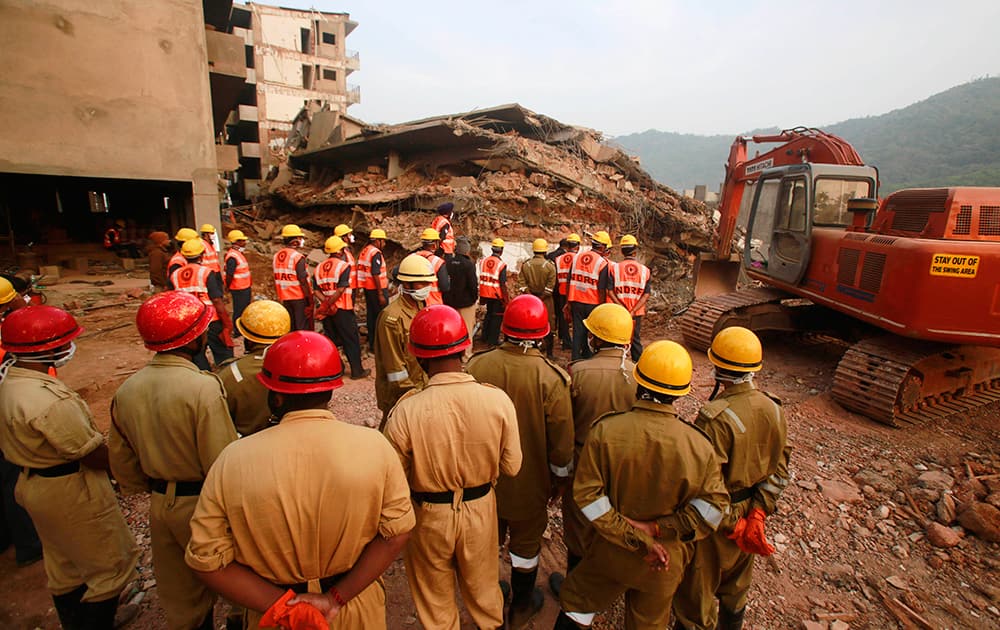 Members of India`s National Disaster Response Force (NDRF) stand watch before their search and rescue operation for survivors in the rubbles of a collapsed building in Canacona, about 70 kilometers (44 miles) from the state capital of Panaji.