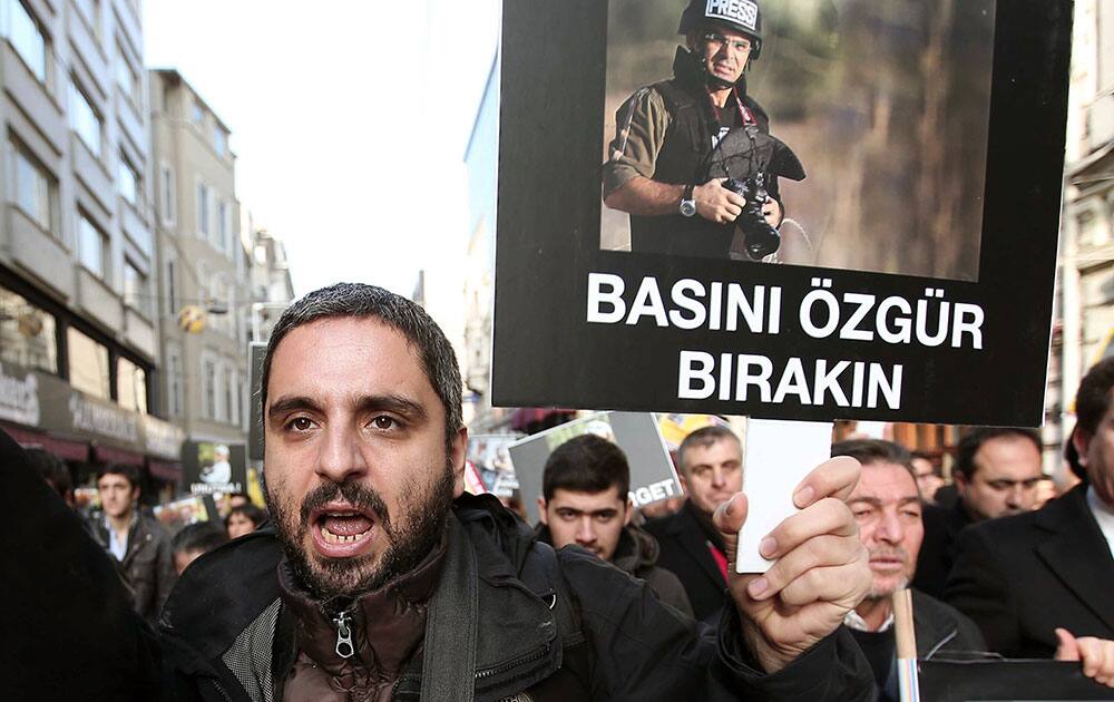 A Turkish shouts as he holds a placard with an image of Bunyamin Aygun, a photographer working for Istanbul daily Milliyet, who was abducted in Syria during November 2013 by armed Syrian opposition groups, during a protest in Istanbul, Turkey.