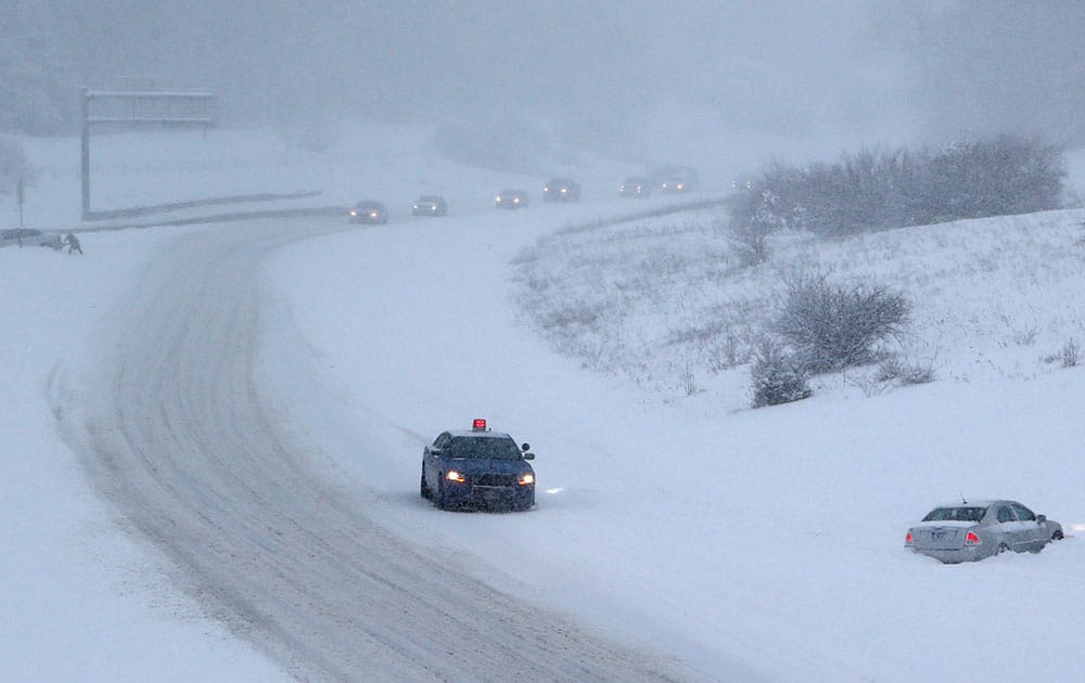 A Michigan State Trooper checks on a motorist who slid off I-75 in Clarkston, Mich. Michigan residents are stocking up in preparation for the harshest winter conditions in 20 years, with a foot of snow already on the ground, more on the way and temperatures expected to dive as low as minus 15.