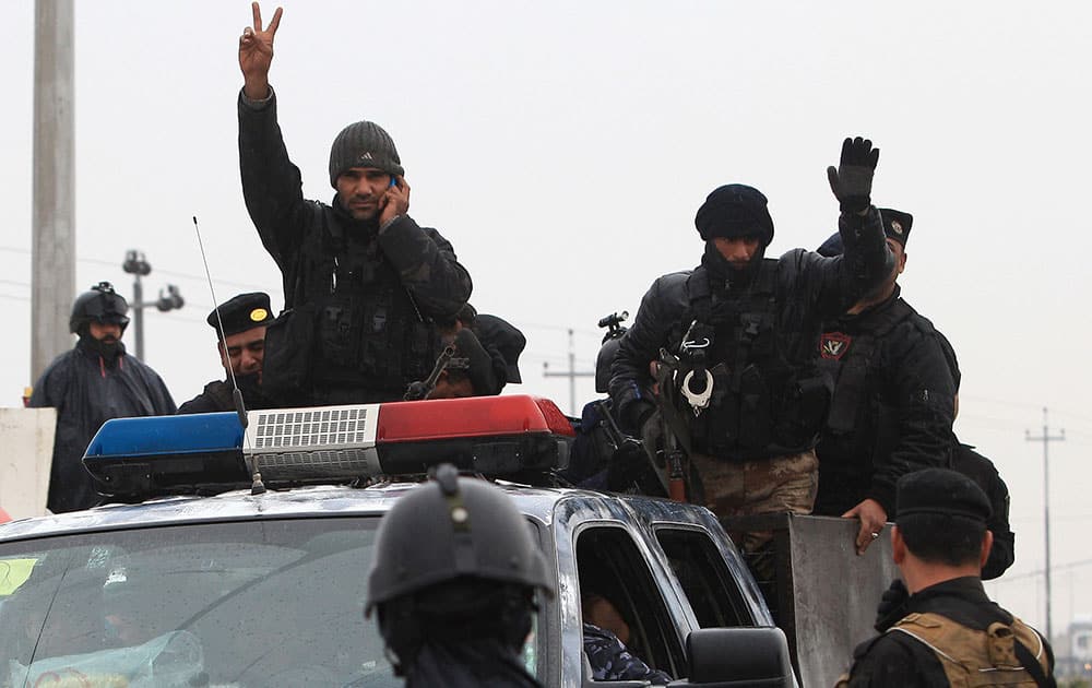 An Iraqi riot police officer flashes the V-sign as his unit returns to its headquarters from clashes between Iraqi army and al-Qaeda fighters in Anbar province, in Basra, Iraq`s second-largest city, 550 kilometers (340 miles) southeast of Baghdad.