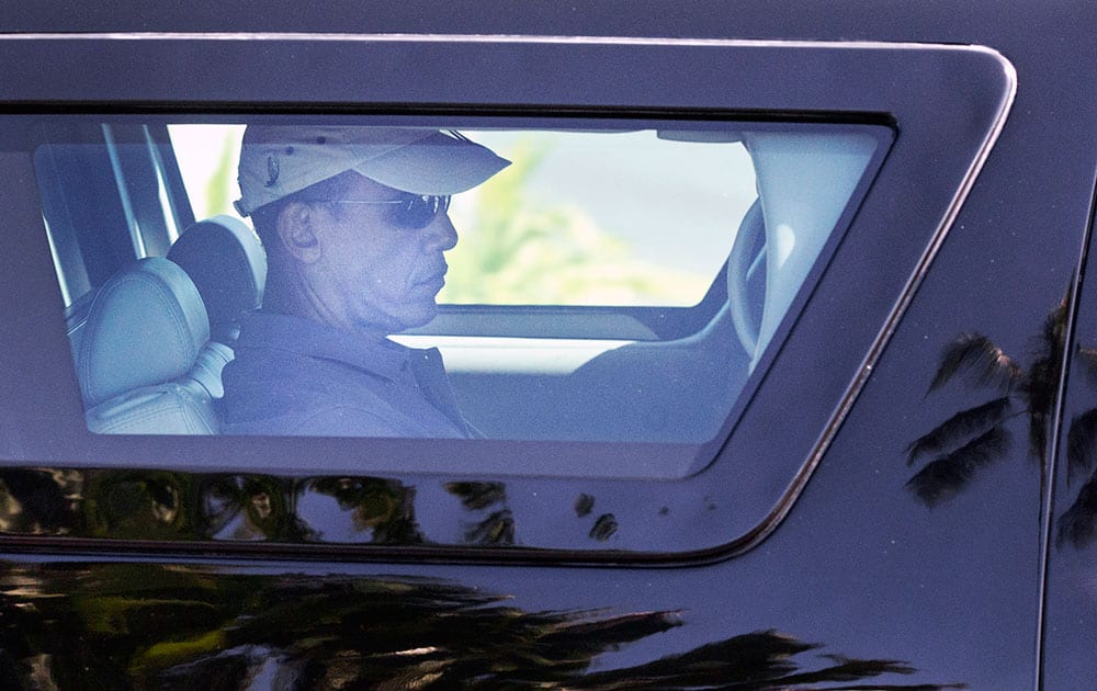 President Barack Obama is seen through the window of his motorcade vehicle as he is driven through the Kailua, Hawaii, neighborhood where he is spending his annual holiday vacation with his family, en route to Marine Corps Base Hawaii, in Kaneohe Bay, Hawaii.