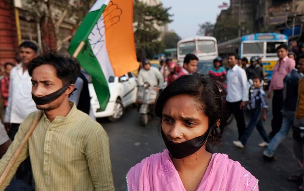 Activists of Indian National Congress with black bands around their mouth block traffic during a protest against a gang-rape and murder of a 16-year-old girl at Madhyamgram, about 25 kilometers (16 miles) north of Kolkata.