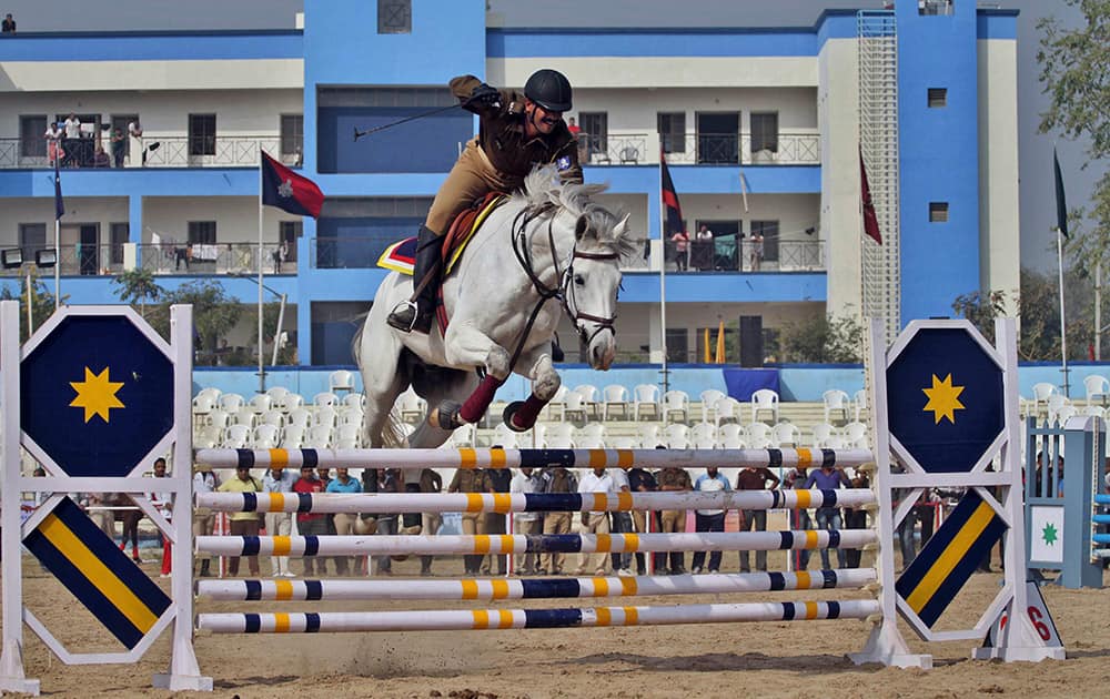 An Indian police horse rider jumps over hurdles during the 32nd annual All India Police Equestrian Meet in Ahmadabad. A total of 18 teams are participating in the weeklong event that began Friday.