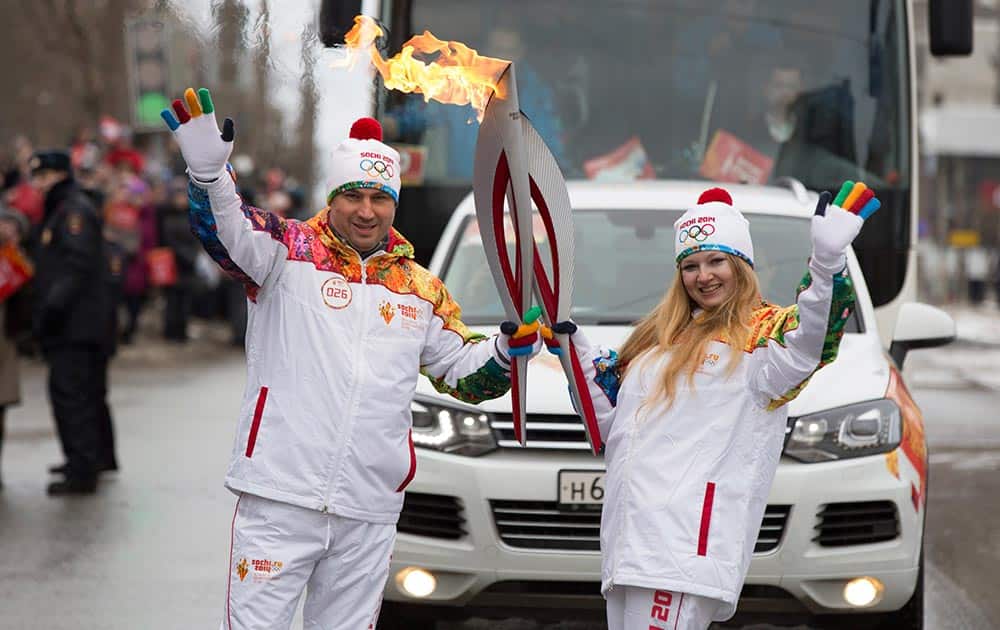 Olympic torch bearers Dmitry Lukin and Yekaterina Nekrasova hold Olympic torches during the torch relay in in Izhevsk, Russia.