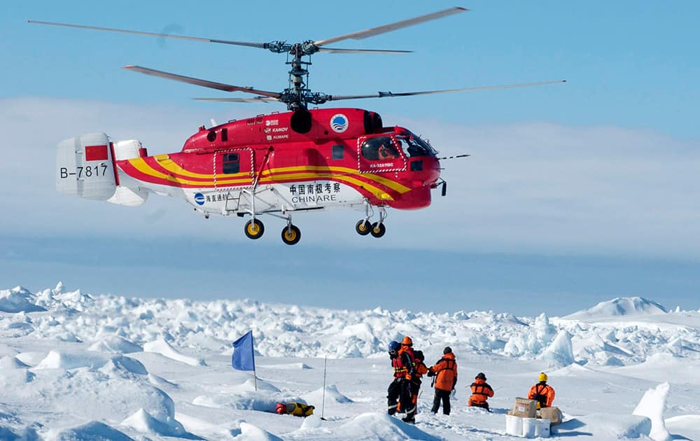 This image provided by Australasian Antarctic Expedition, passengers trapped for more than a week on the icebound Russian research ship MV Akademik Shokalskiy are rescued by a Chinese helicopter.