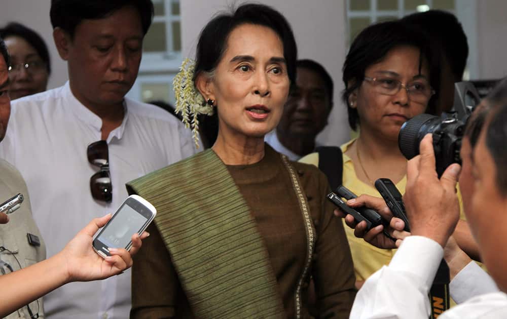 Myanmar opposition leader Aung San Suu Kyi talks to journalists during a press briefing after meeting with members of parliament, government officials and members of non-government organizations in Yangon, Myanmar.