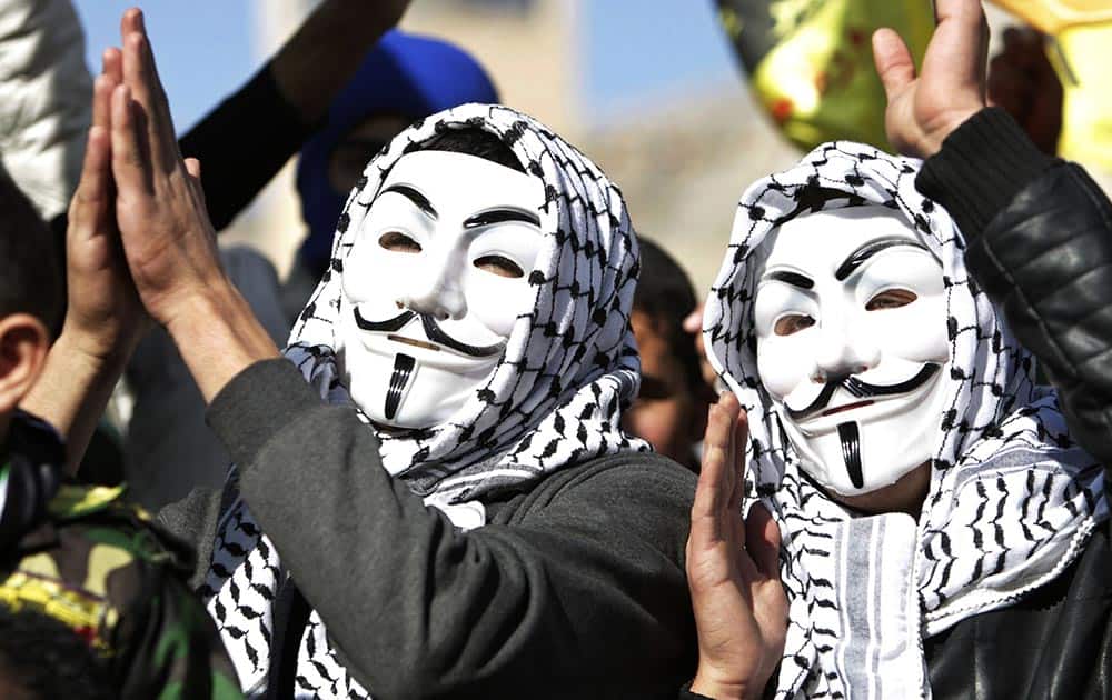 Palestinians wearing `Guy Fawks` masks celebrate as they mark the 49th anniversary of the Fatah movement during a rally in the West Bank city of Nablus.