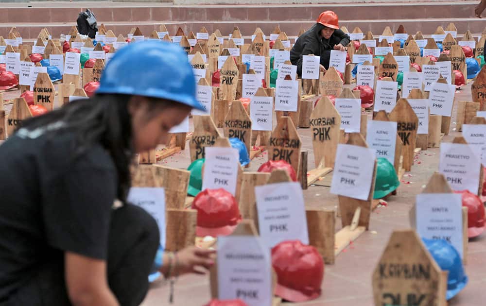 Activists of National Solidarity of Mine Workers (SPARTAN) arrange mock graves of miners during a protest against the government`s plan to ban raw mineral exports that will take effect on Jan 12, in Jakarta, Indonesia.