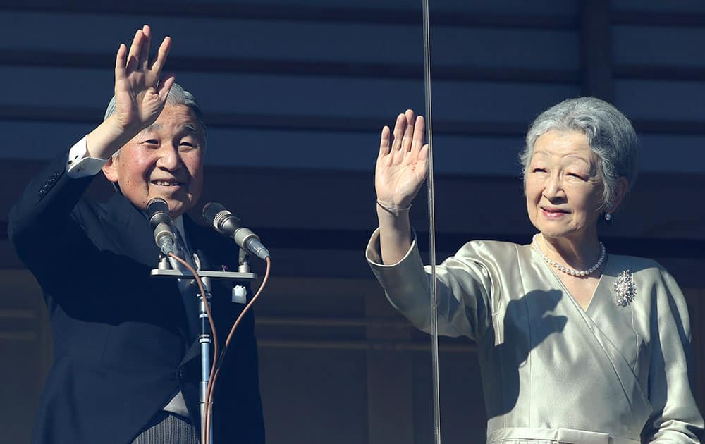 Japan`s Emperor Akihito and Empress Michiko wave to well-wishers from a balcony during a New Year`s public appearance at the Imperial Palace in Tokyo.