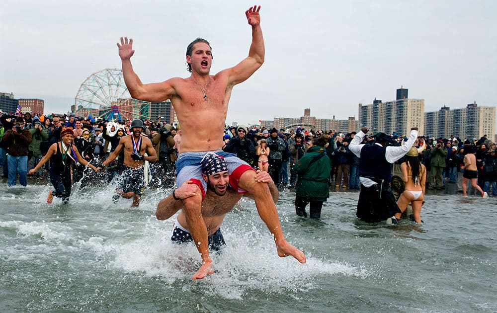 Swimmers jump into frigid waters at Coney Island beach in New York, as they take part in the 111th Annual New Year`s Day Polar Bear Plunge.