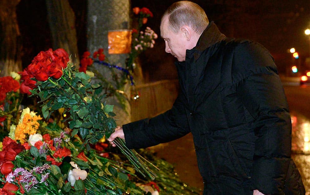 Russian President Vladimir Putin places flowers outside the wreckage of a trolleybus in Volgograd, Russia.
