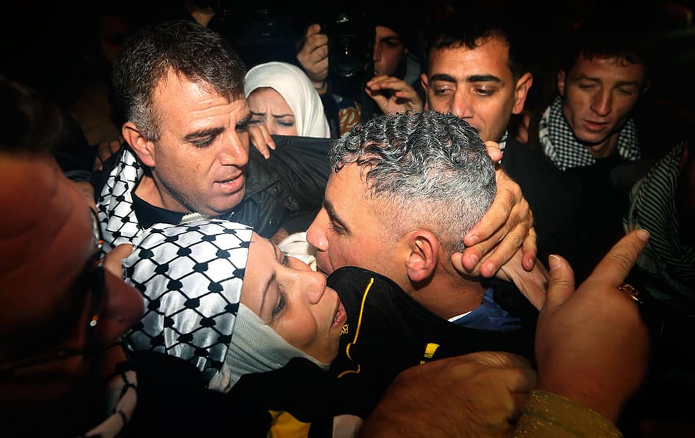 Rami Barbakh, a released Palestinian prisoner, center, is reunited with his mother as he arrives at a checkpoint at the entrance of the northern Gaza town of Beit Hanoun.