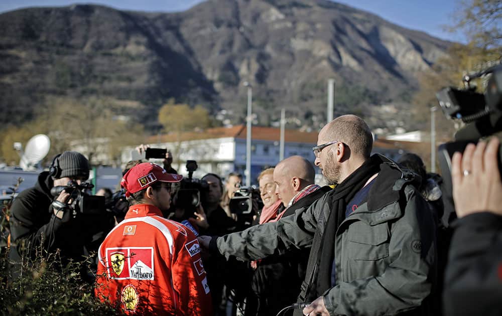 A Scuderia Ferrari fan talks to journalists, in front of the Grenoble hospital, in the French Alps, where former seven-time Formula One champion Michael Schumacher is being treated after sustaining a head injury during a ski accident, in Grenoble, France.