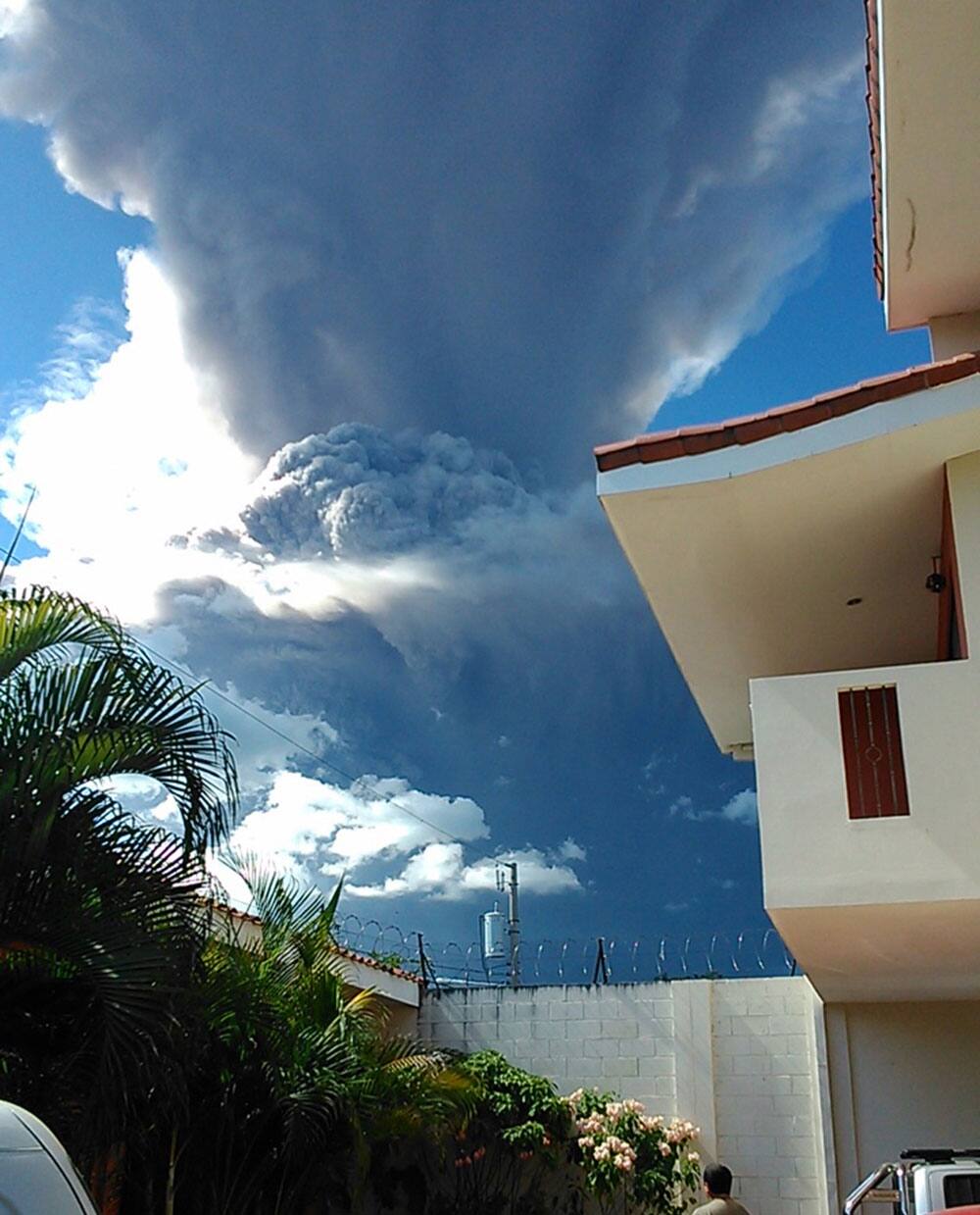 A man watches as the Chaparrastique volcano shoots a a cloud of gas and ash about three miles (five kilometers) into the air in the city of San Miguel, El Salvador.