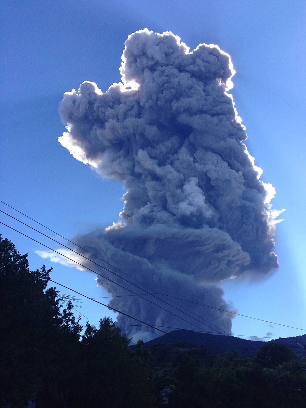 The Chaparrastique volcano shoots a a cloud of gas and ash about three miles (five kilometers) into the air as seen from the city of San Miguel, El Salvador.