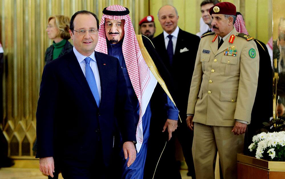 Saudi Arabia`s King Abdullah, right, escorts French President Francois Hollande upon his arrival to Riyadh, Saudi Arabia.