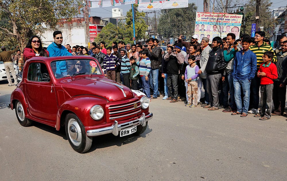 People ride in a 1948 Fiat Topolino 500 B during a vintage car rally in Allahabad, India. The event was organized by Allahabad Museum.