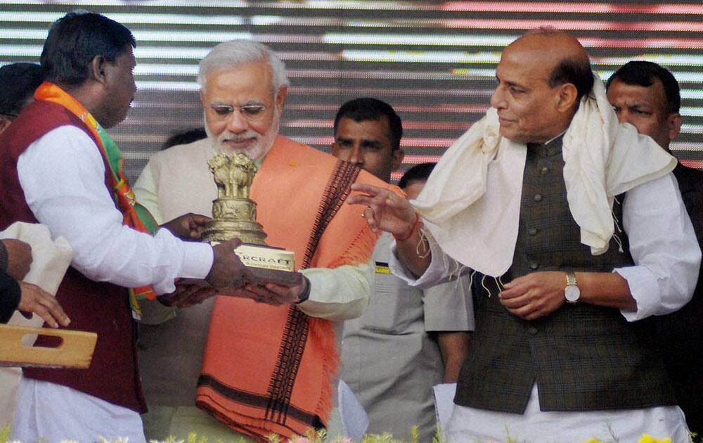 BJP`s Prime Ministerial candidate Narendra Modi being presented a memento by former state Chief Minister Arjun Munda as party President Rajnath Singh looks on during Vijay Sankalp rally in Ranchi.