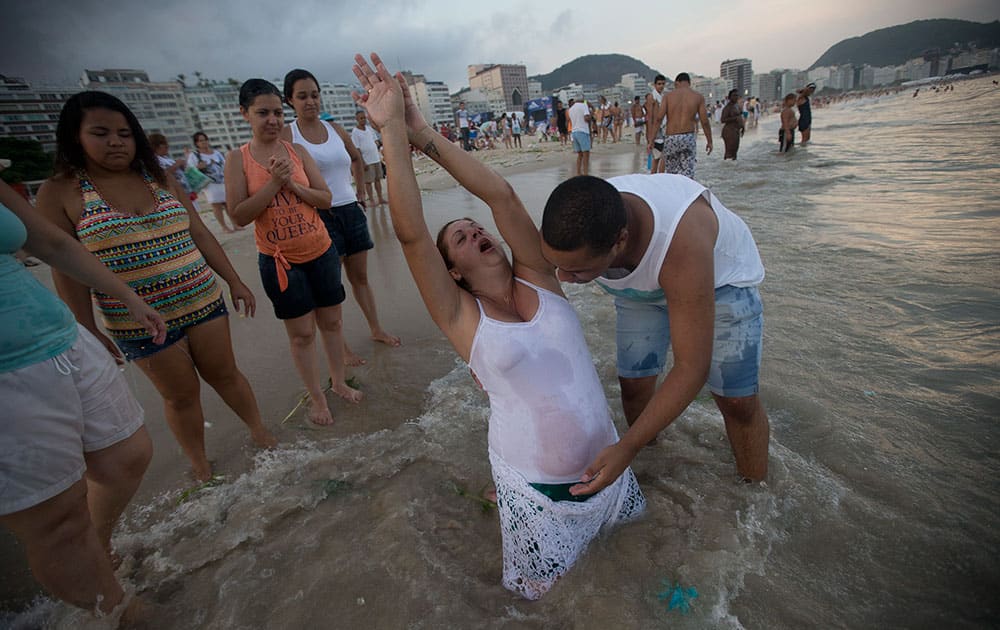 A woman in a trance holds up her arms up during the celebration for Yemanja, goddess of the sea, in Rio de Janeiro, Brazil.