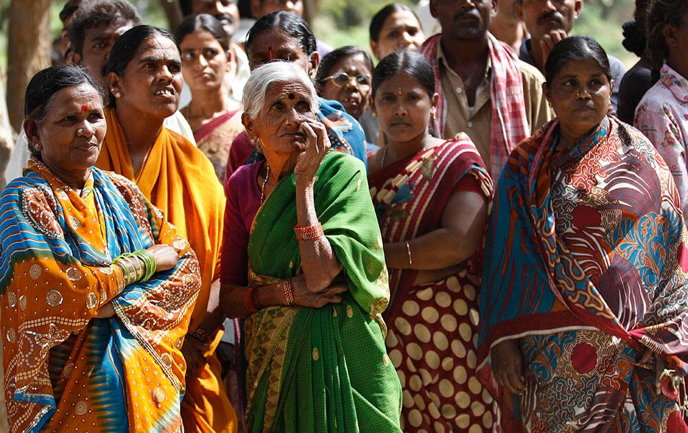 A crowd gathers to watch hospital staff and volunteers carry charred bodies of passengers near the site of a train accident at Kothacheruvu, about 155 kilometers north of Bangalore, India.