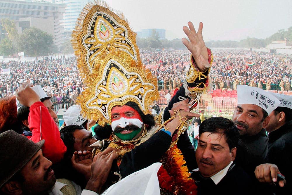 AAP supporters celebrate at the oath taking ceremony of party leaders at Ramlila maidan in New Delhi.