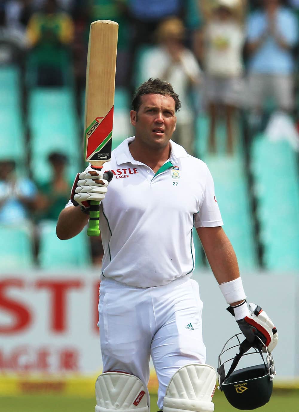 South Africa`s batsman Jacques Kallis raises his bat after reaching a half century on the third day of their cricket test match against India at Kingsmead stadium, Durban.