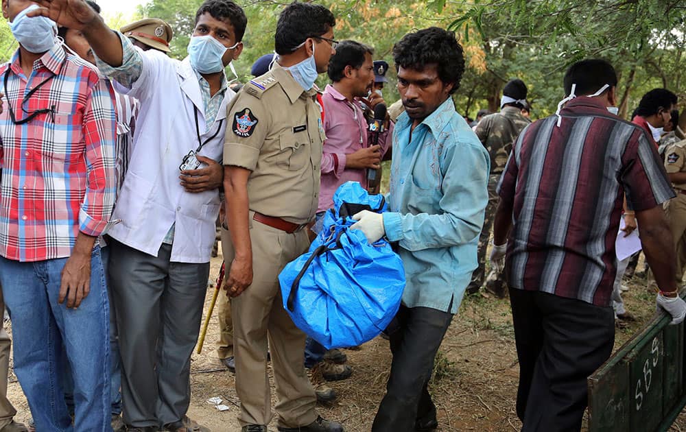 A volunteer carries the remains of a charred body of a passenger near the site of a train accident at Kothacheruvu, about 155 kilometers (96 miles) north of Bangalore.