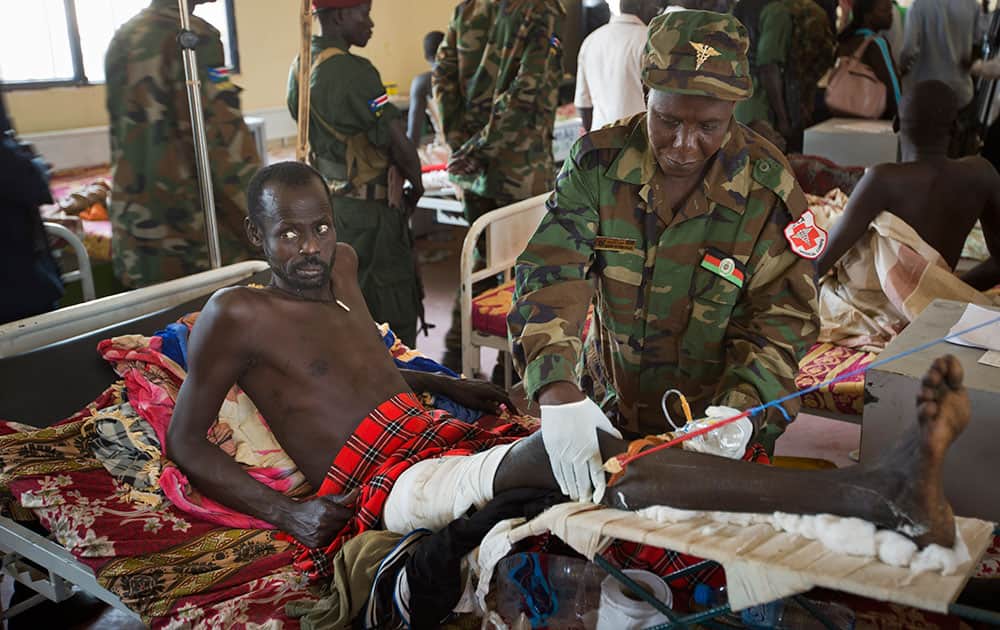 A patient is treated by a military doctor in a ward of mainly soldiers with gunshot wounds, during a visit by current Vice-President James Wani Igga, at the Juba Military Hospital in Juba, South Sudan.
