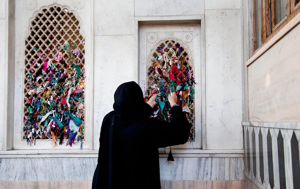 A Kashmiri woman ties a thread on the window of the shrine of Sufi saint Hazrat Sheikh Hamza Makhdoom, commonly known as Sultan-Ul-Arifeen, on the eve of the saint`s Urs, in Srinagar.