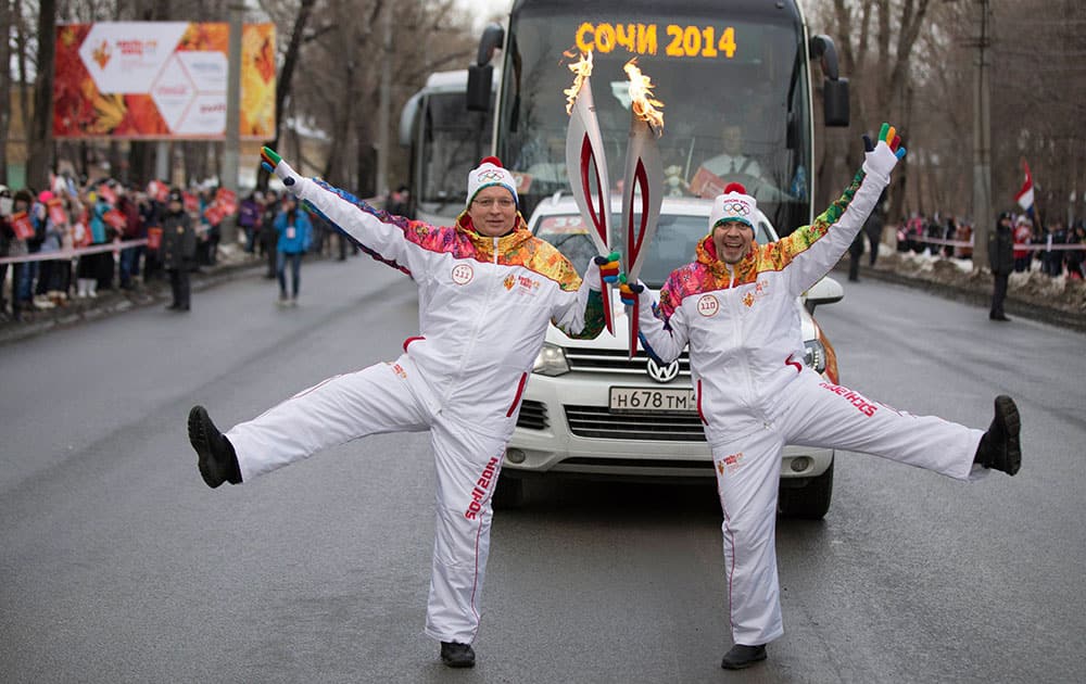 Torch bearers, Andrei Golovanov, left, and Dmitry Ramzanov pose during the Olympic torch relay in Samara on the Volga River, in Russia. The 65,000-kilometer (40,389 mile) Sochi torch relay, which started on Oct. 7, is the longest in Olympic history.