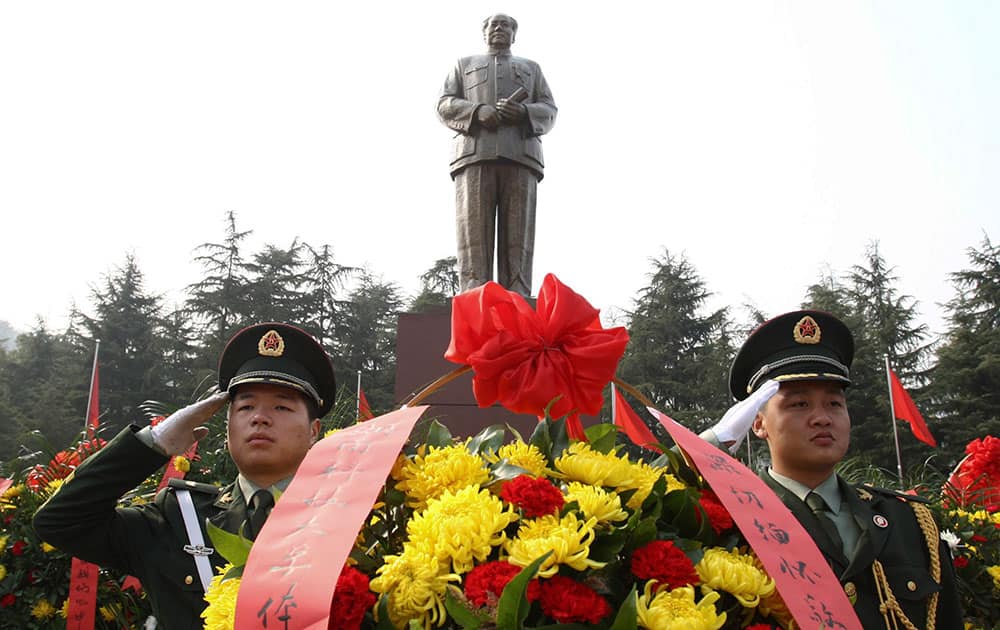 Security guards salute near wreaths in front of a statue of the late Communist leader Mao Zedong in Shaoshan, Mao`s hometown, in southern China`s Hunan province.