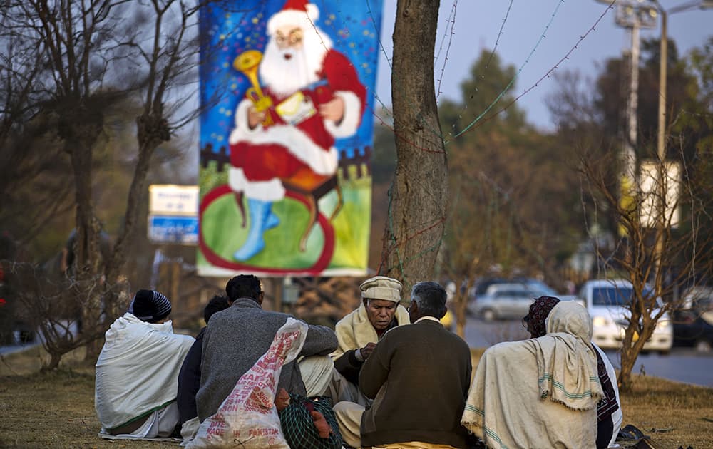 Pakistani Christians play cards on a roadside near their neighborhood ahead of Christmas in Islamabad.
