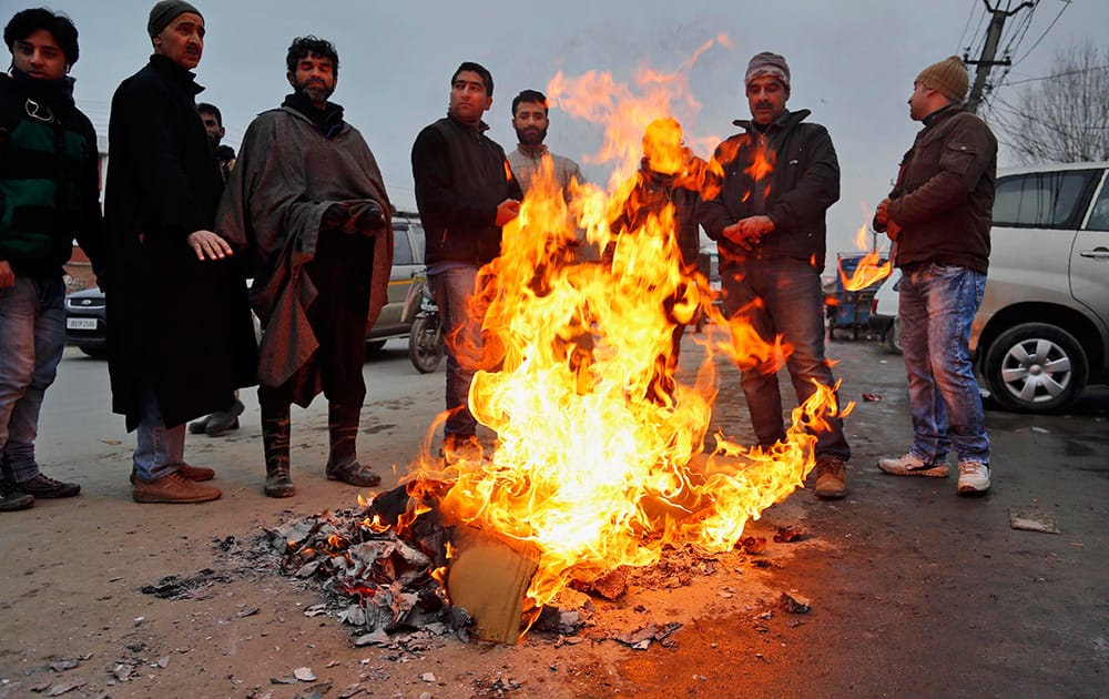 Kashmiri men warm their hands near a bonfire on a cold day in Srinagar. The Kashmir valley continues to reel under intense cold wave for the past few days with widespread snowfall in the hilly areas.