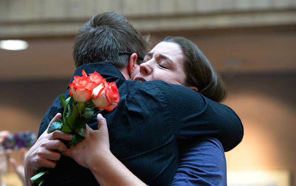 Emily Holmes, right, embraces her wife Heather Pope after being married in the lobby of the Salt Lake County offices.