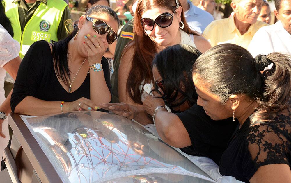 Luz Consuelo Martinez, wife of singer and composer Diomedes Diaz, top left, mourns over his coffin at the main square in Valledupar, in Colombia`s northern state of Cesar.