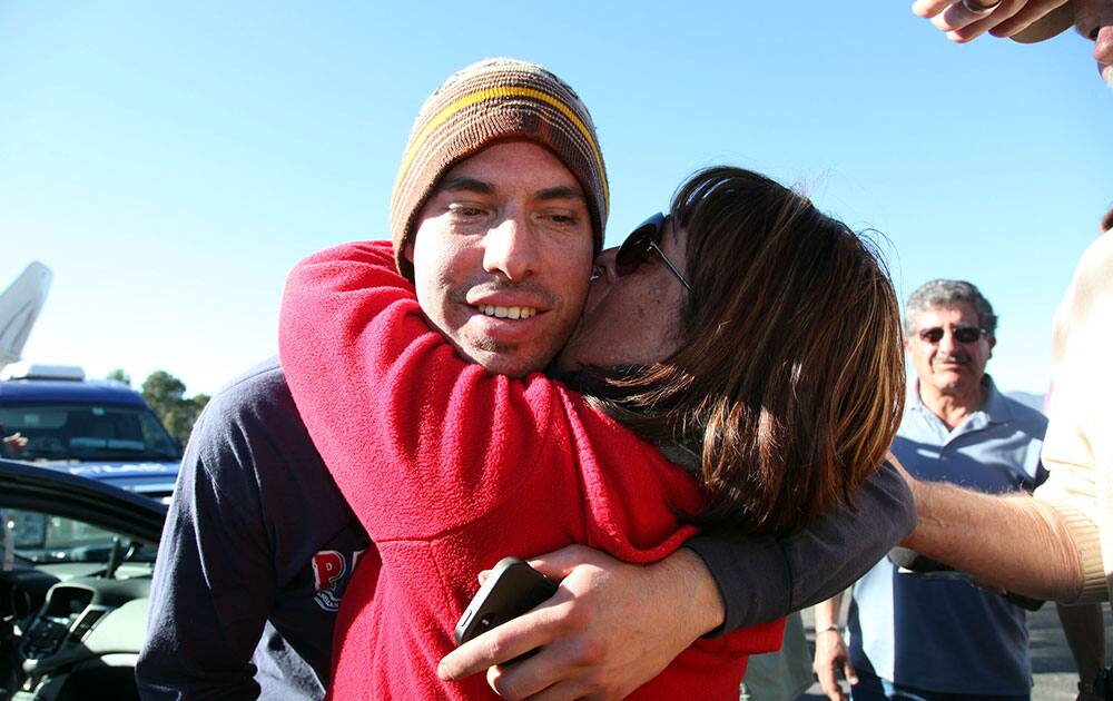 Elsa McCarthy kisses her son, Christopher McCarthy, after he and three other mountain bikers were found safe by search and rescue teams, after spending a night in the chilly Angeles National Forest near Pasadena, Calif.